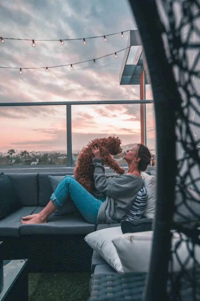 Woman on porch smooching her dog